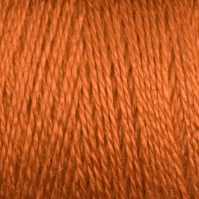 Close-up image of an earthy orange spool of 8/2 Tencel Yarn | Mini Cone by Maurice Brassard, neatly wound and showcasing the texture and sheen of the fibers. The individual strands of the thread create a subtle, repetitive pattern, perfect for knitting accessories or weaving projects.