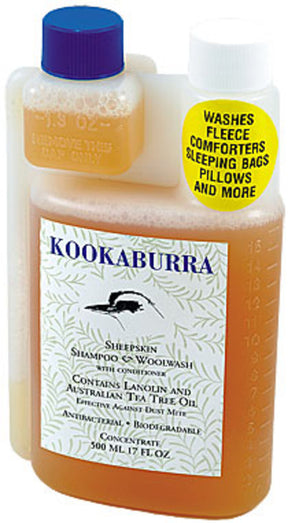 A 500 ml bottle of Kookaburra Woolwash by ABL Development, Inc., featuring a black bird silhouette and labeled with lanolin and Australian tea tree oil. A yellow sticker indicates it washes fleece, comforters, sleeping bags, pillows, and more.