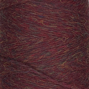 Close-up view of a spool of JaggerSpun Heather 3/8 wool yarn from Jagger Brothers, Inc., featuring a mix of deep maroon, brown, and subtle hints of other earthy tones. The yarn strands are tightly wound together, showcasing a textured and slightly fuzzy appearance.