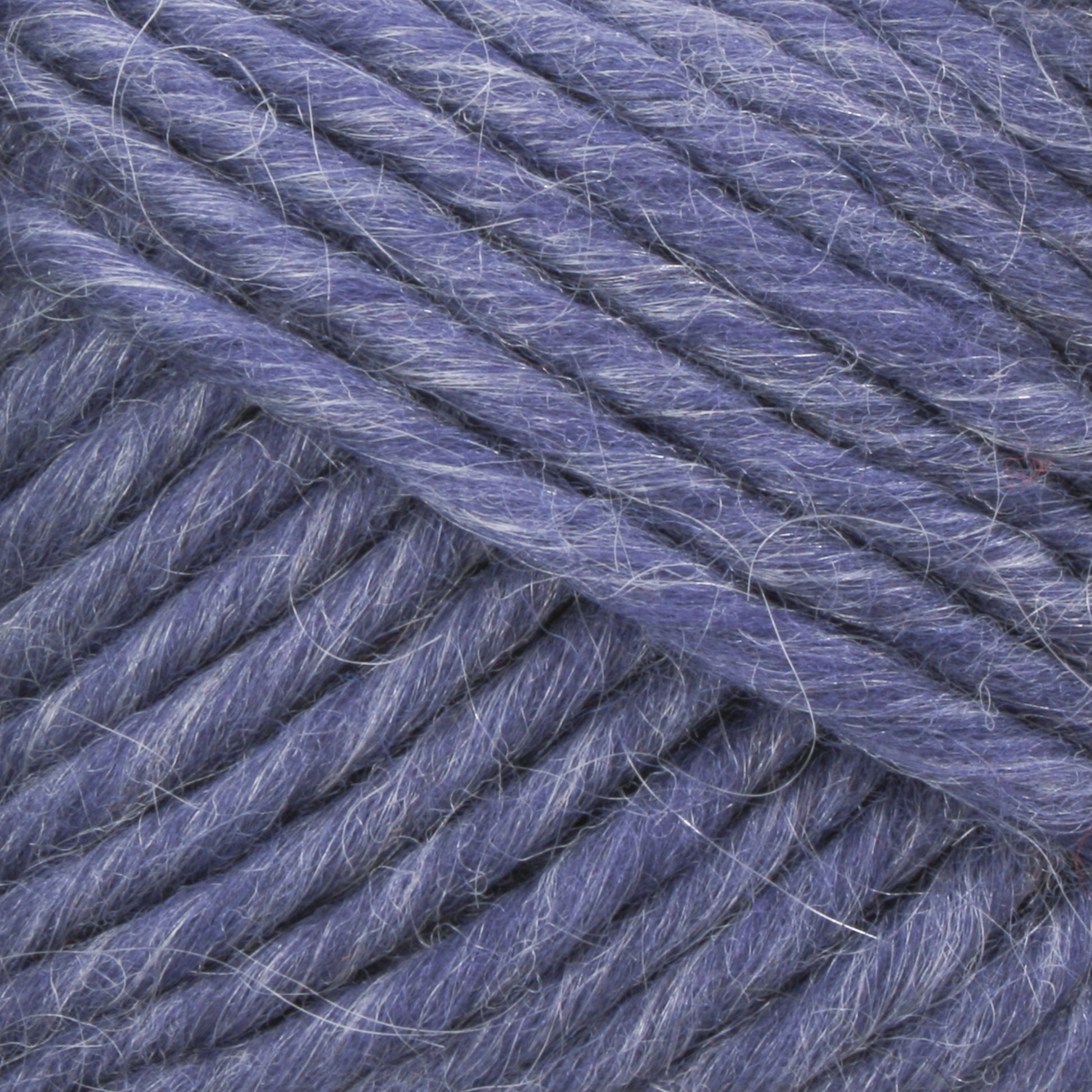 Close-up of Lamb's Pride Bulky Yarn by Brown Sheep reveals thick, soft, blue threads with a slightly fuzzy texture. The tightly wound strands display shades of lighter and darker blue, likely due to natural light and shadow. Ideal for knitters and crocheters, the fibers are clearly visible, highlighting the yarn’s fluffiness and softness.