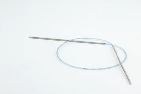 A pair of Addi Turbo Circular Knitting Needles by Skacel, featuring two stainless steel tips with one slightly longer than the other, is displayed against a plain white background. The flexible blue cable ensures precision and safety in knitting projects, similar to how detailed medical guidewires perform in delicate medical procedures.