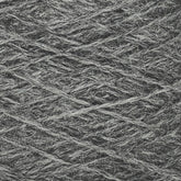 A close-up view of JaggerSpun Heather 3/8 yarn by Jagger Brothers, Inc. showcases its dark gray wool fibers, intricately and tightly wound. The texture appears soft and slightly fuzzy, with strands running diagonally across the image to create a crisscross pattern typical of worsted spun yarns.