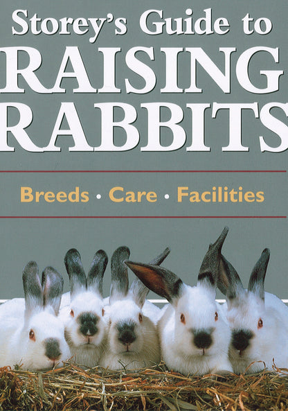 The hardcover edition of "Storey's Guide to Raising Rabbits" by Workman Publishing - Storey features a cover photo of five white rabbits with black-tipped ears sitting on hay. The text "Breeds, Care, Facilities" is displayed on a green background. This comprehensive guide provides indispensable insights into rabbit care, including information on Angora rabbits.