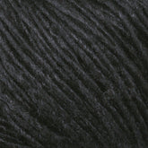 Close-up of Malabrigo Silky Merino, showcasing its fibrous texture. The yarn strands are tightly wound together, creating a soft and slightly fuzzy appearance. The texture and dark color suggest it could be used for knitting or crocheting dense fabric items, perfect for those looking to create rich, dark-colored projects.