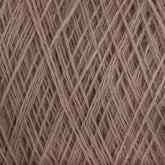 Close-up of JaggerSpun Maine Line 2/20 Yarn in beige. The tightly wound fibers from Jagger Brothers, Inc. create a textured pattern with intersecting lines and overlapping strands, giving a crisscross effect. The yarn appears soft and slightly fuzzy.