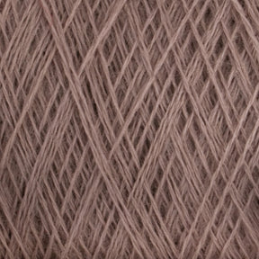 Close-up of JaggerSpun Maine Line 2/20 Yarn in beige. The tightly wound fibers from Jagger Brothers, Inc. create a textured pattern with intersecting lines and overlapping strands, giving a crisscross effect. The yarn appears soft and slightly fuzzy.