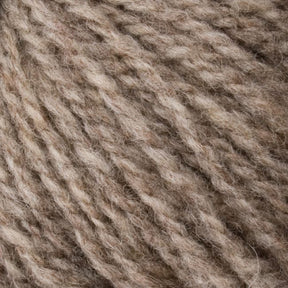 Close-up of soft, textured beige yarn fibers twisted into strands, creating a cozy and natural appearance. The Bartlettyarns "Bartletts Maine Wool - Sport" yarn appears fluffy and inviting, suitable for knitting or crafting projects.