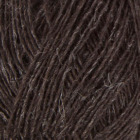 Close-up view of dark brown Einband Lopi wool by Berroco, Inc. with a slightly rough texture. The strands are intertwined, showing a mix of darker and lighter fibers throughout, providing a natural and rustic appearance ideal for lace knitting projects.