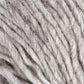 Close-up image of Jöklalopi (Bulky Lopi) yarn in grey by Berroco, Inc. showcases its soft, slightly fuzzy texture. The loosely twisted strands reveal individual fibers and their natural imperfections, exuding a rustic handmade charm. The neutral color and unique texture suggest it is ideal for knitting or crocheting cozy garments like chunky winter sweaters.