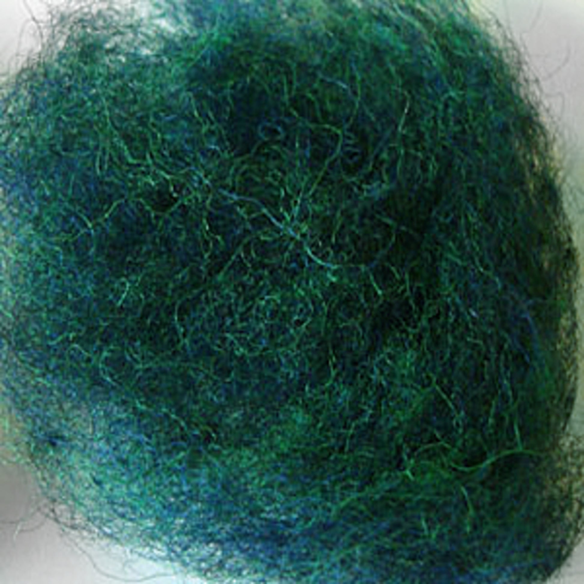 Close-up image of Harrisville Designs' Harrisville Dyed & Carded Wool Fiber, showcasing a dense, tangled ball of fine green and blue fibers that resemble steel wool or a mass of thread. The heathered colors of the interwoven fibers create a textured, fuzzy appearance ideal for felting wool projects.