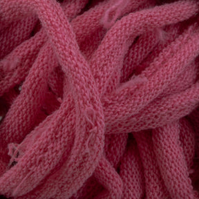 A close-up image of Harrisville Potholder Loops - Traditional Size Mini Pack by Friendly Loom showcases pink, knitted fabric strands intertwined and piled together. The texture appears soft and fluffy with some fraying on the edges, reminiscent of cotton loops woven on a traditional loom, giving a cozy, handmade feel.