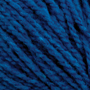 Close-up image of blue Harrisville Shetland Yarn - Unwashed Cones by Harrisville Designs. The texture and twisted strands of the yarn are clearly visible, showcasing the fibers and depth of color, perfect for intricate Fair Isle knitting designs.