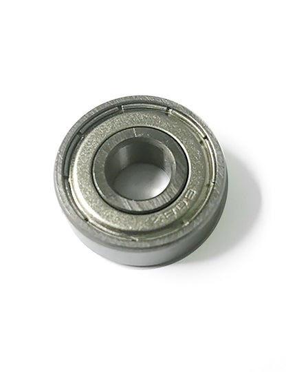 A detailed view of the Louët Spinning Wheel Ball Bearing by Louët Inc. showcases the cylindrical design featuring an outer ring, an inner ring, and a circular row of balls in between. The bearing has a metallic, shiny surface and is prominently displayed against a plain white background, making it ideal for use in a Louët wheel.