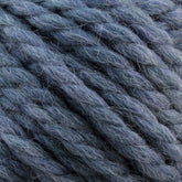 Close-up of ultra-soft, thick, twisted yarn in various shades of gray and blue, showcasing the texture and fibers of the material. This chunky Baby Alpaca Grande by Plymouth from Plymouth Yarn Co. appears perfect for knitting or crocheting projects requiring a touch of luxury.