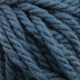 Close-up view of thick, soft yarn in a heathered, dusty blue color, showing the individual strands twisted together. The texture appears wooly and slightly fuzzy, much like Halcyon Yarn Rug Wool by Caledonian Dye Works used by rug weavers, ideal for cozy knit or crochet projects.