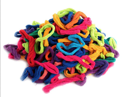 A vibrant pile of Harrisville Potholder Loops - Traditional size Lotta Loops Pack by Friendly Loom, made from a stretchy, textured material, is displayed against a white background. Resembling the loops used in a potholder loom, the loops come in various colors including red, blue, green, purple, yellow, and orange, creating a visually appealing and cheerful assortment.