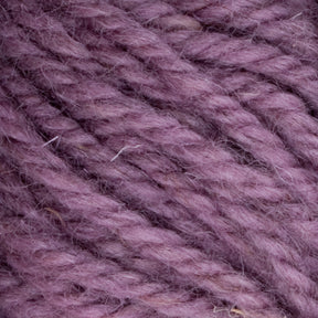 Close-up view of Halcyon Yarn Classic Rug Wool | Skein from Caledonian Dye Works, featuring a soft, thick texture in a muted lavender color. The strands are twisted tightly together, showcasing a slightly fuzzy appearance. Perfect for weavers, this hand-dyed yarn highlights the intricate details and fibers of rug wool.