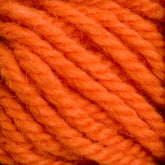 Close-up image of bright orange, thick strands of Halcyon Yarn Classic Rug Wool by Caledonian Dye Works, intertwined in a repetitive pattern that emphasizes the textured and fiber details typical of hand-dye techniques used by skilled weavers.