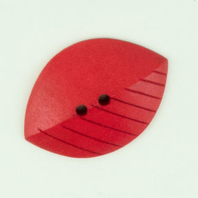 A vibrant red "Wood Leaf" button by Buttons Etc. features a leaf shape with two small center holes, a slanted dividing line, and several parallel grooves on one side for added texture and detail. It is set against a plain, light-colored background.