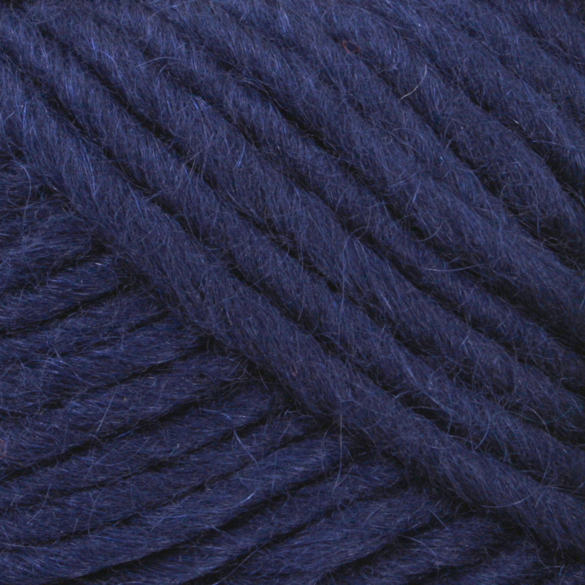 Close-up image of dark blue yarn fibers. The yarn appears thick and well-twisted, with visible texture and strands in varying shades of blue, ideal for felting projects using Brown Sheep's Lamb's Pride Worsted Yarn.