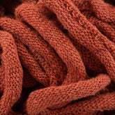 Close-up view of a pile of intricately knitted, rust-colored Harrisville Potholder Loops - Traditional Size Mini Pack by Friendly Loom, forming a textured and intertwined pattern reminiscent of a traditional loom.