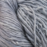 Close-up of a skein of Malabrigo Silky Merino by Malabrigo Yarn. The soft, thick, light grey yarn is coiled with visible texture, showcasing its slightly fluffy and smooth fibers.