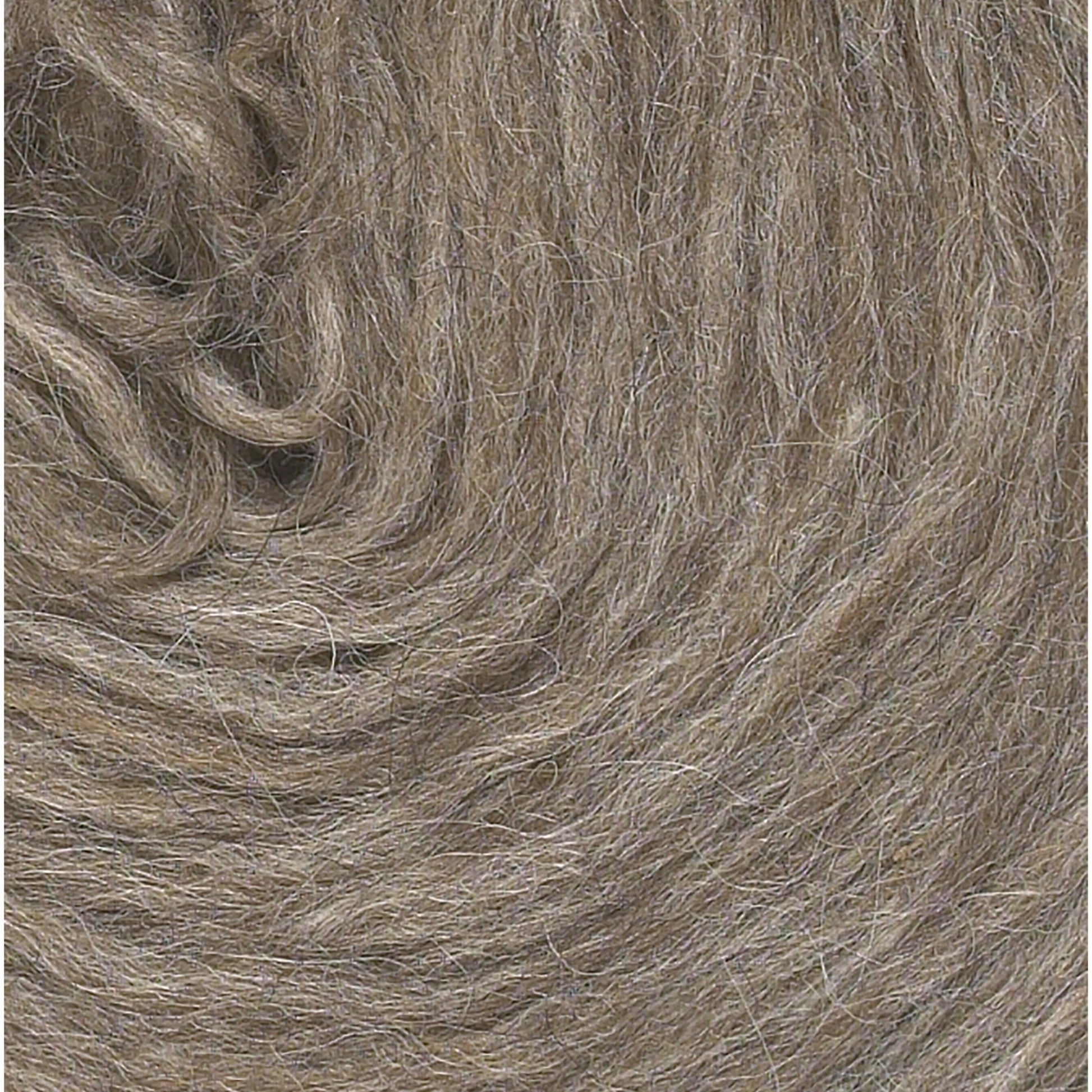 Close-up image of soft, grey and light brown fibers from Berroco's Plötulopi Unspun Icelandic Wool Yarn arranged in a circular pattern. The texture appears fluffy and intertwined, depicting natural, unprocessed wool.