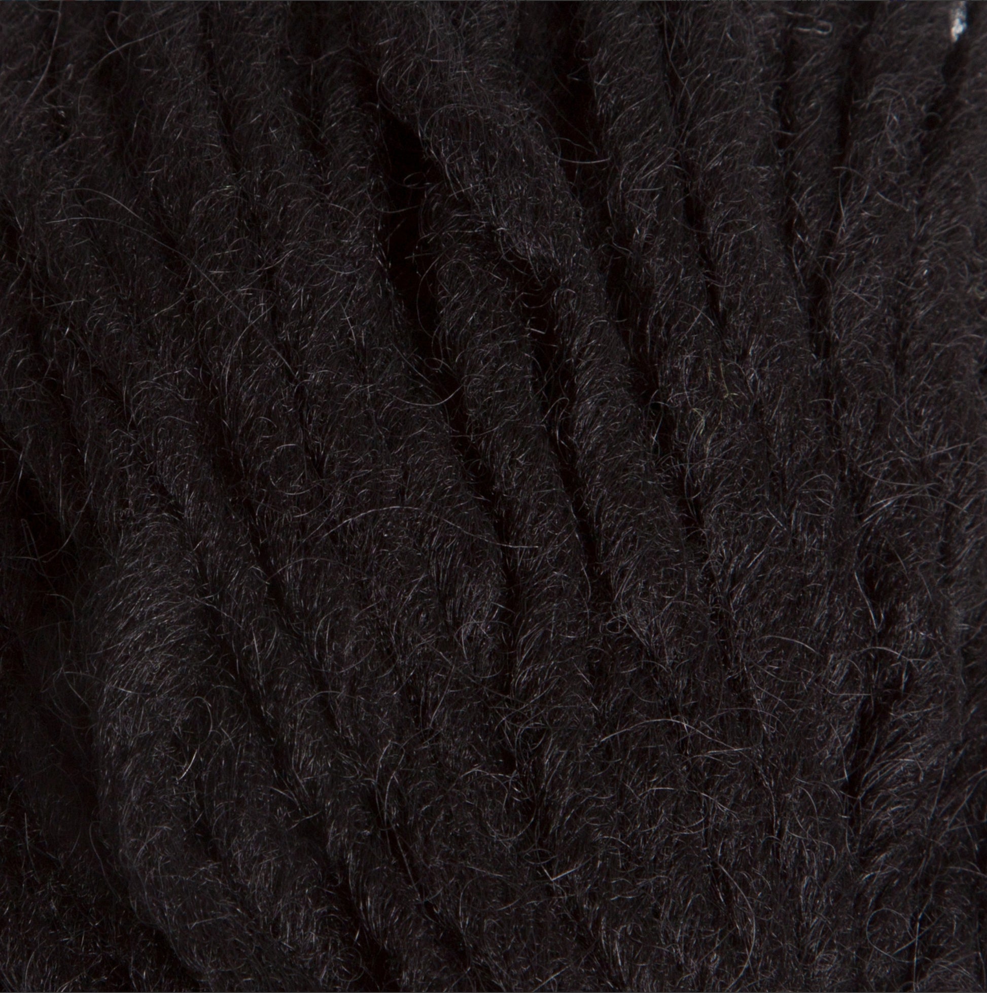 Close-up of Berroco, Inc.'s Jöklalopi (Bulky Lopi) in thick, dark brown wool yarn with a slightly fuzzy texture. The strands are tightly wound together, creating a dense and textured surface, perfect for crafting chunky winter sweaters that exude rustic handmade charm.