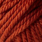 Close-up image of thick, rust-colored Jo Sharp Silkroad Ultra yarn by Kingfisher Yarn & Fibre. The twisted fibers form a tightly wound coil, displaying a rich and earthy tone. The texture of the chunky cuddly yarn appears super soft and suitable for knitting or crocheting cozy winter accessories.