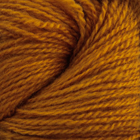 A close-up shot of a ball of Jade Sapphire Cashmere 2-Ply yarn in a rich mustard yellow color. The texture of the hand-dyed fibers from Jade Sapphire Exotic Fibres is clearly visible, showing fine strands tightly twisted together to form a thick, cohesive bundle. The overall appearance is warm and cozy, perfect for finely knit sweaters or woven accessories.