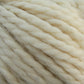 Close-up of thick, cream-colored Baby Alpaca Grande yarn twisted together, showing the texture and strands in detail. The ultra-soft yarn from Plymouth Yarn Co. appears perfect for knitting or crocheting cozy garments and accessories. The color is uniform and light, with slight variations in shade, ideal for bulky weight projects.