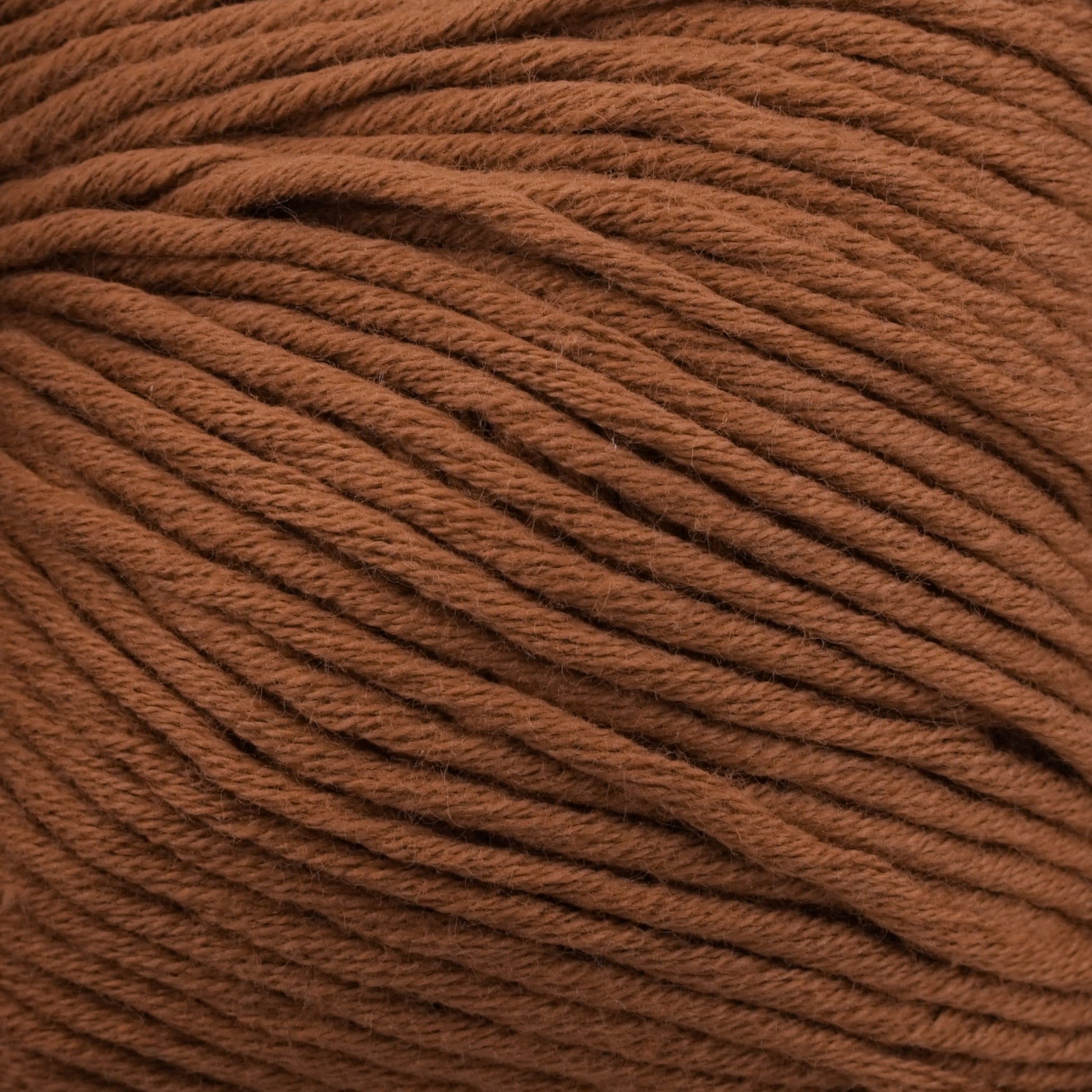 Close-up of a skein of Jo Sharp Soho Summer DK Cotton from Kingfisher Yarn & Fibre. The texture is visible, showcasing its smooth and tightly woven strands. The color is a rich, warm brown, perfect for creating lightweight summer garments.