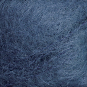 Close-up image of Victorian Brushed Mohair Yarn from Caledonian Dye Works, showcasing its fluffy and soft texture in varying shades of light blue. The delicate fibrous material, with fine strands, creates a wispy and airy appearance reminiscent of luxurious mohair. Available in large skeins.