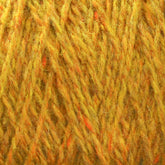 A close-up image of a bundle of Harrisville Highland - Cones by Harrisville Designs featuring shades of yellow and orange, with a mix of fibers creating a textured appearance. The yarn appears soft and fuzzy, showing intricate detail in the twists and strands.