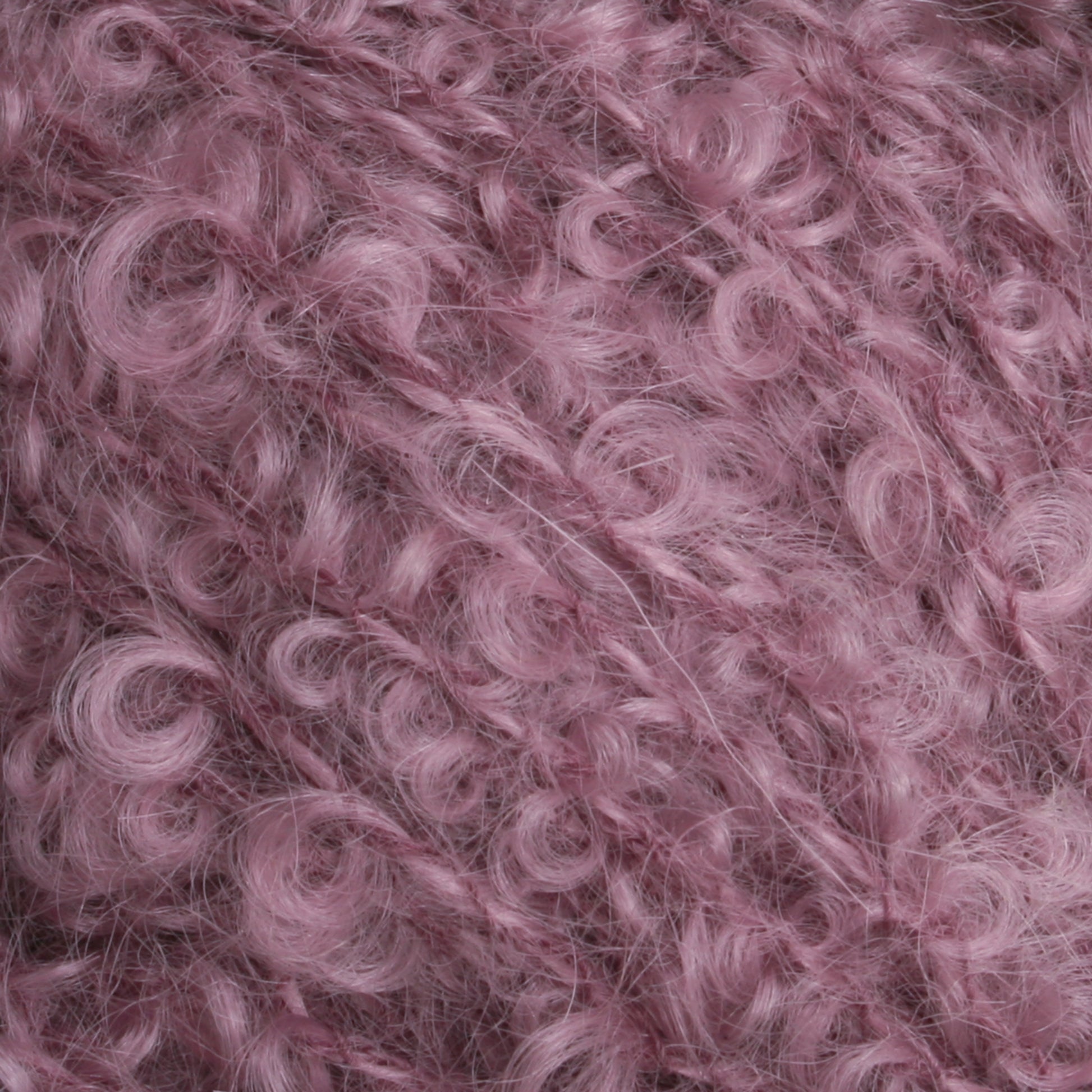 Close-up image of a textured pink yarn from Caledonian Dye Works' Victorian Bouclé Mohair Yarn. The yarn features a fuzzy and curly appearance, with tightly wound loops and soft strands, creating a plush and cozy look. The pink hue adds a warm and inviting feel to the intricate mohair bouclé texture.