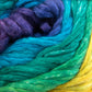 Close-up image of Cumulus Cotton by Juniper Moon Farm, distributed by Knitting Fever / Euro Yarns, featuring intertwined strands of green, blue, turquoise, purple, and yellow. The soft yarn appears thick yet delicate, creating a vibrant and textured pattern with its durable chainette construction.