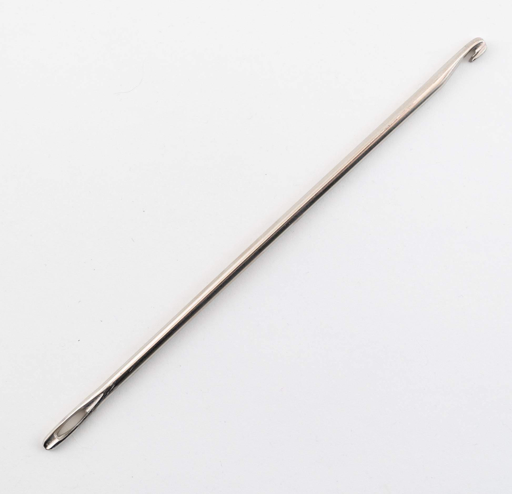 A smooth, metallic tool known as the Locker Hook by Notions Marketing, featuring a hook at one end and a large eye at the other commonly used for crafting locker hooking projects, is photographed against a plain white background. It appears to be a knitting or crochet needle.