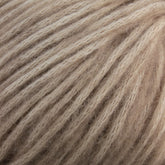 Close-up image of soft, beige-colored Katia Cotton-Merino yarn by Knitting Fever / Euro Yarns. The individual strands are loosely twisted, giving a fluffy and slightly fuzzy appearance with a subtle heathered effect, suitable for knitting or crocheting warm, cozy garments.