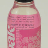 A 90mL, clear plastic bottle of Soak Wash, a delicate wash liquid laundry detergent from Soak Wash Inc. The bottle contains a pink liquid and is adorned with decorative floral patterns along with the words "celebration" and "pure clean fun" on its label. It features a black flip-top cap and is biodegradable.