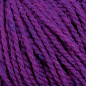 Close-up image of Harrisville Highland - Cones by Harrisville Designs. The unscoured purple yarn strands, infused with spinning oils, are tightly twisted, showcasing varying shades of purple that add depth and texture.