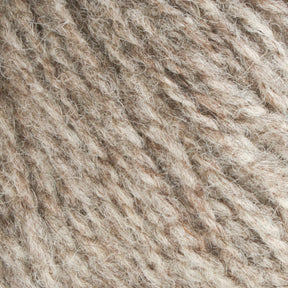 Close-up image of Bartlettyarns' Maine Wool Yarn in textured beige and light brown, showcasing the intricate, fibrous pattern characteristic of this worsted weight yarn from Bartlettyarns. The tightly interwoven strands produce a soft, fuzzy surface with a blend of natural, heathered colors.