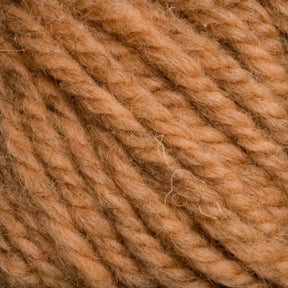 Close-up image of a ball of thick, textured yarn in a light brown, tan color. The strands are twisted together, creating a cozy, woven appearance with visible fibers. This Caledonian Dye Works Halcyon Yarn Classic Rug Wool | Skein captures the soft texture and earthy tone favored by weavers for their craft.