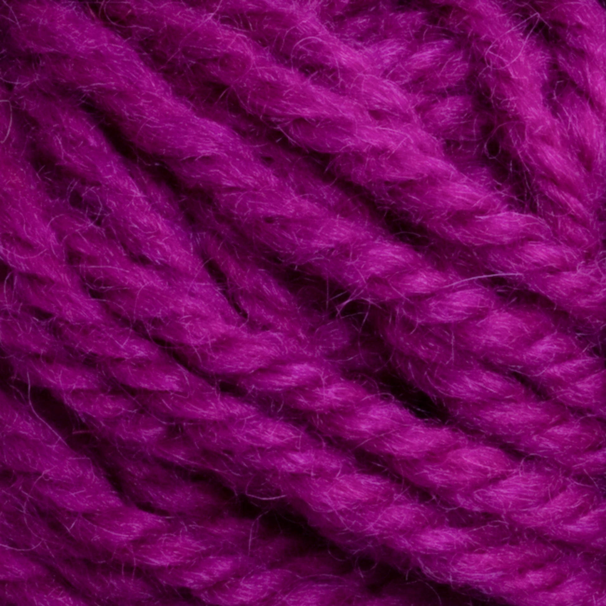 Close-up image of thick, twisted yarn in a vibrant magenta color, showcasing its fibrous texture and interwoven strands—perfect for rug weavers using Halcyon Yarn Classic Rug Wool from Caledonian Dye Works.