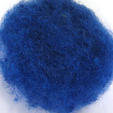 A close-up image of a small ball of blue lint against a white background. The lint, reminiscent of Harrisville Dyed & Carded Wool Fiber by Harrisville Designs, is tangled and fibrous, with a vivid blue color and a slightly fuzzy texture.