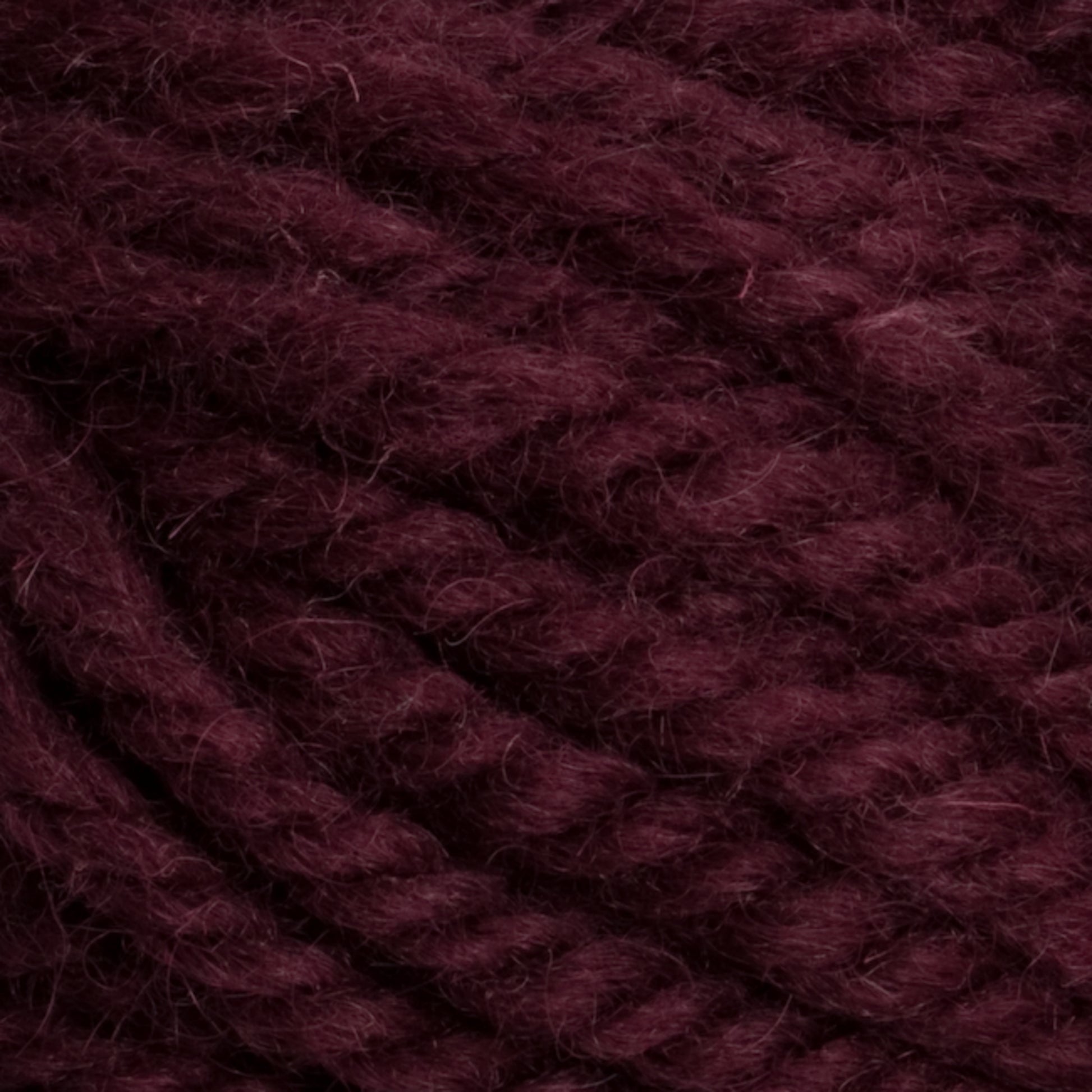 Close-up image of thick, twisted burgundy yarn strands. The yarn fibers are tightly woven, displaying a rich, deep reddish-purple color and a soft, fuzzy texture—perfect for rug weavers who appreciate the quality of hand-dye techniques in Caledonian Dye Works' Halcyon Yarn Classic Rug Wool.