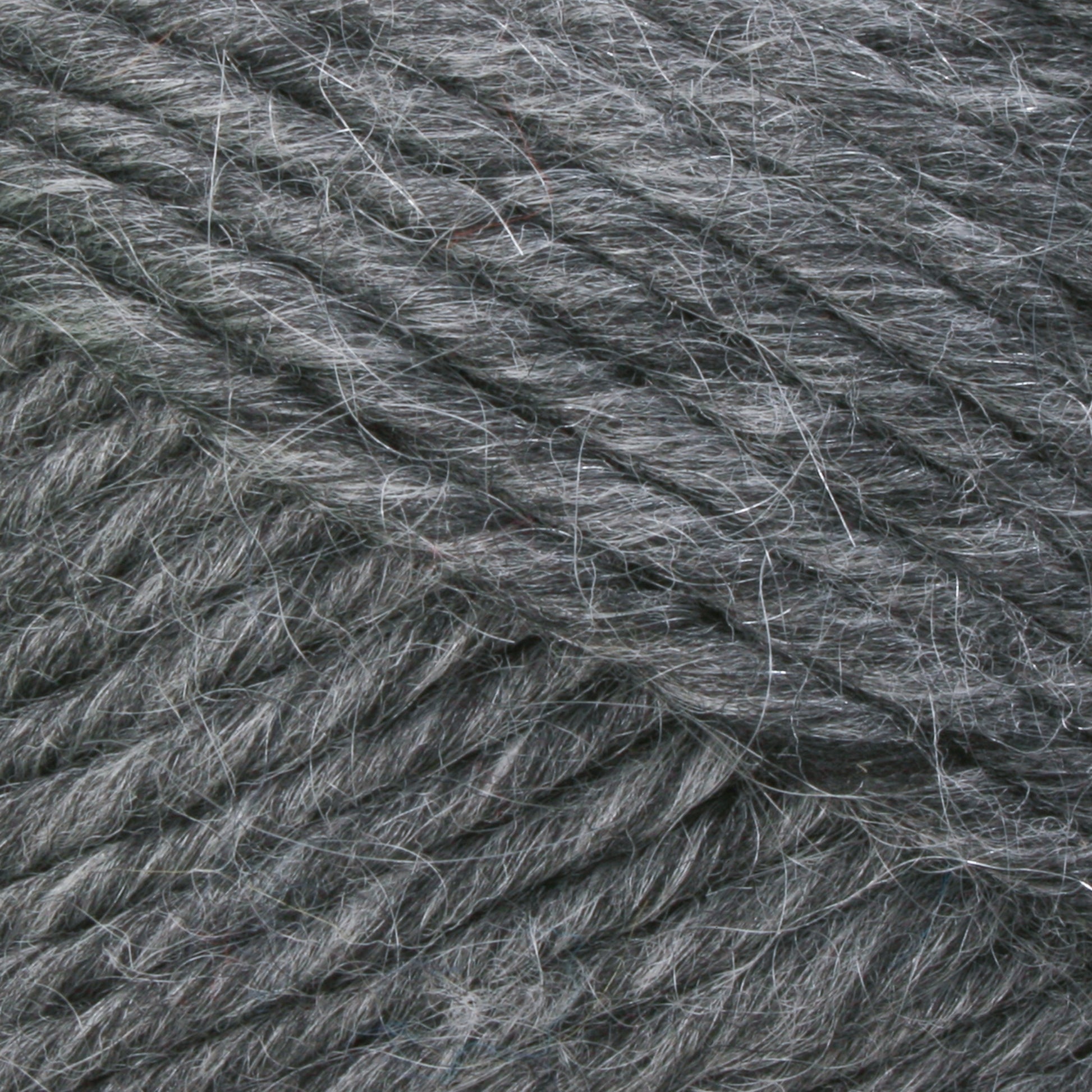 Close-up of a ball of Lamb's Pride Bulky Yarn by Brown Sheep, perfect for knitters and crocheters, showcasing the strands tightly wound together. The yarn has a slightly textured and fuzzy appearance with visible fibers sticking out.