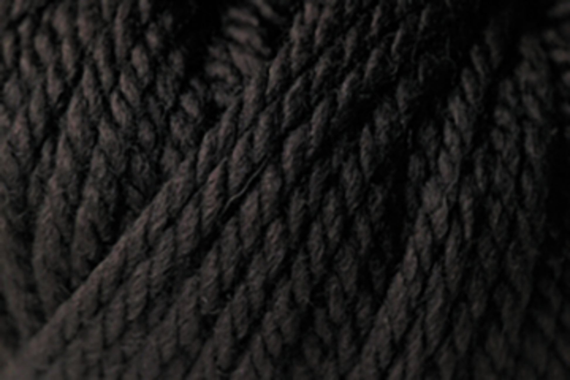 Here is a close-up of the Jo Sharp Silkroad Ultra, by Kingfisher Yarn & Fibre, showcasing its thick, twisted texture. The tightly wound strands create a dense and super soft appearance. The lighting emphasizes the texture and fibers, providing a detailed view of this material, making it ideal for cozy winter accessories.