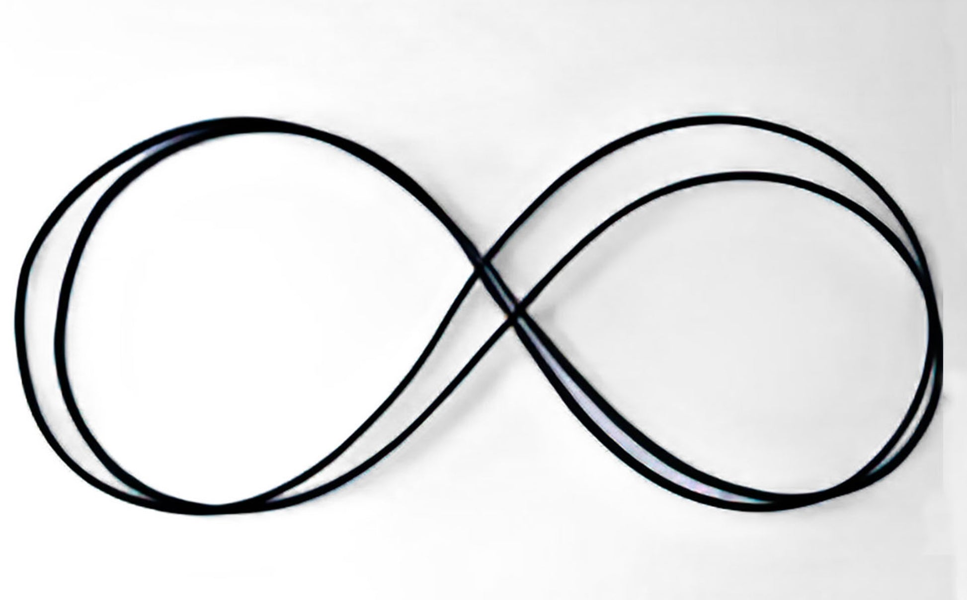 A Louët Spinning Wheel Drive Band from Louët Inc. is arranged in a smooth, continuous figure-eight loop against a plain white background.