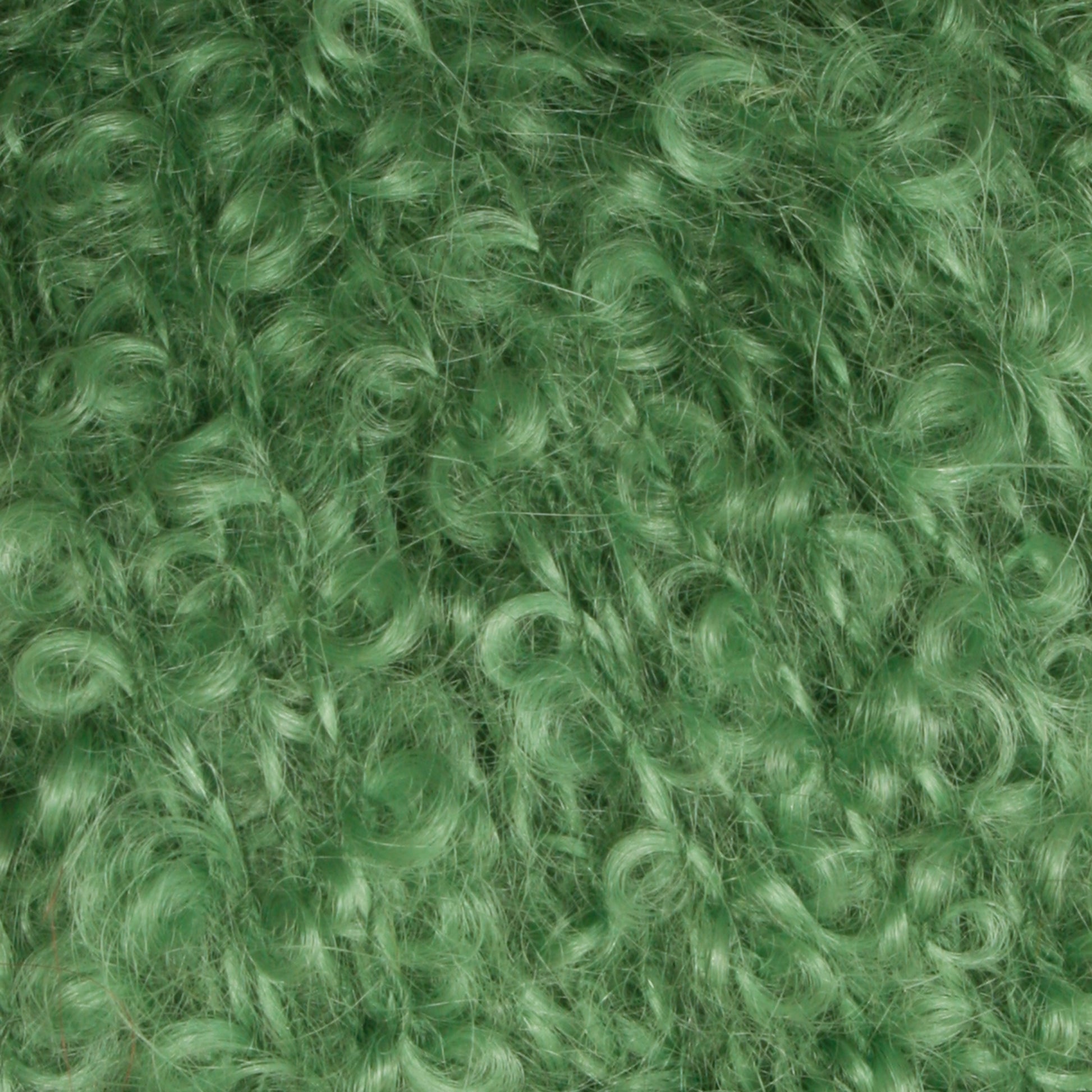 Close-up of the Victorian Bouclé Mohair Yarn by Caledonian Dye Works. The image captures tight, spiraled curls densely packed together, resembling either synthetic material or the distinct texture of bouclé. The overall appearance is bright and vibrant with a green hue.