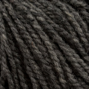 Close-up of thick, dark gray and slightly twisted yarn strands, highlighting their coarse texture and woolly appearance. The Tuffy Canadian Sock Yarn by Briggs & Little fibers appear to vary slightly in shade, adding depth and dimension to the overall texture, making it perfect for crafting cozy winter socks.